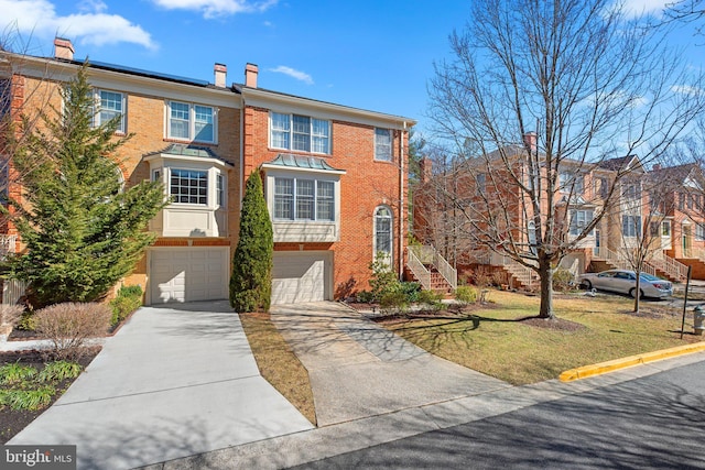 multi unit property featuring concrete driveway, an attached garage, brick siding, and a front lawn