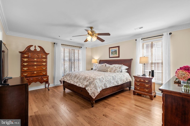 bedroom with visible vents, light wood-style flooring, ornamental molding, and multiple windows