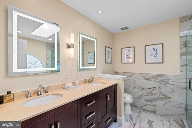 bathroom featuring visible vents, marble finish floor, a skylight, and a sink