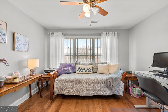 bedroom with visible vents, ceiling fan, baseboards, and wood finished floors