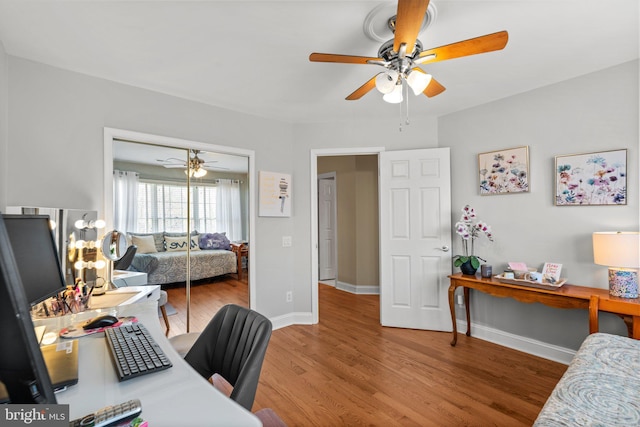 office featuring wood finished floors, baseboards, and ceiling fan