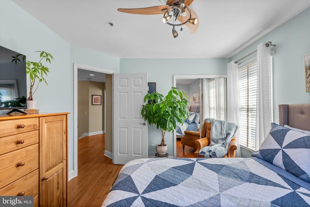 bedroom featuring ceiling fan, baseboards, and wood finished floors