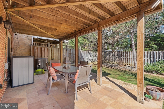 view of patio featuring outdoor dining area, cooling unit, and a fenced backyard