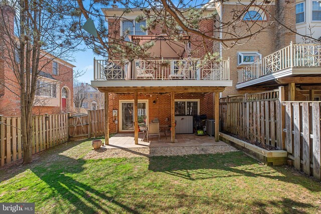 back of property featuring brick siding, a fenced backyard, a patio, and a yard