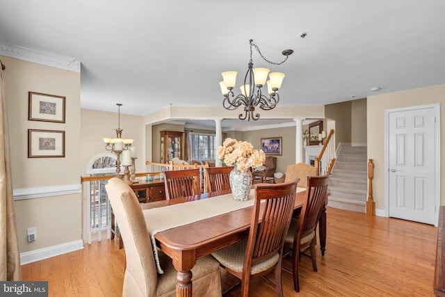 dining room featuring a notable chandelier, light wood-style flooring, baseboards, and decorative columns