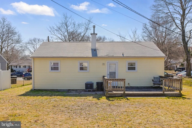 rear view of house featuring a deck, cooling unit, a lawn, and fence