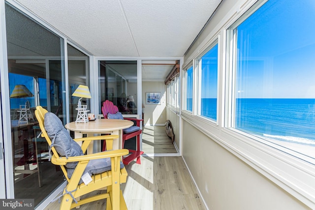 sunroom featuring a water view