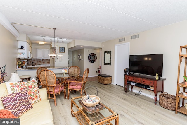 living room featuring visible vents and light wood-style floors