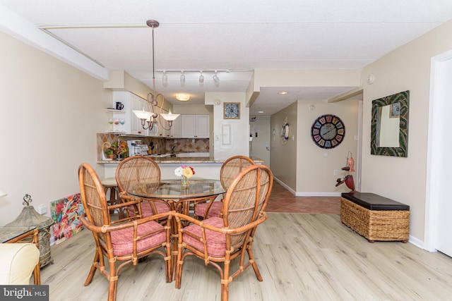 dining space with baseboards and light wood-style floors