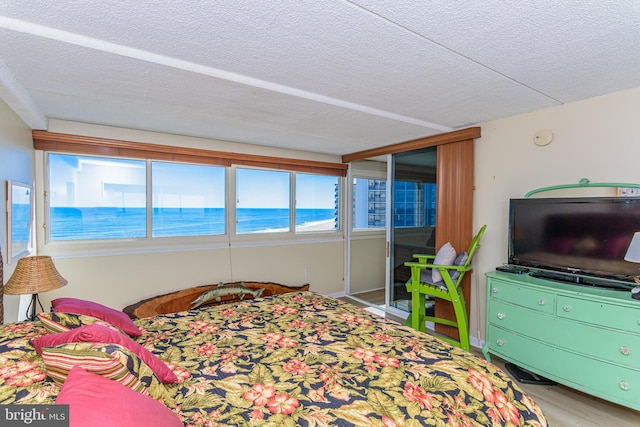 bedroom with a closet, a textured ceiling, and wood finished floors