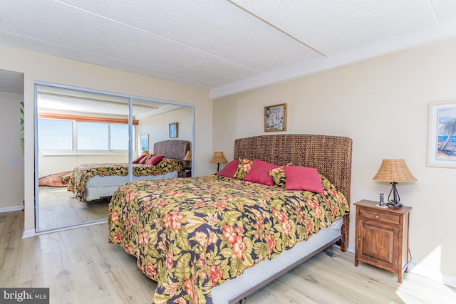 bedroom featuring wood finished floors, a closet, and baseboards