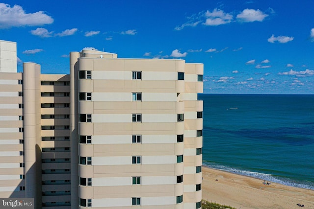 view of building exterior with a water view and a view of the beach