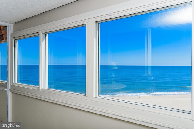 interior space with a water view and a textured ceiling