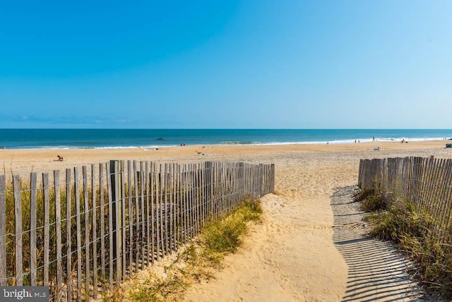 water view with a view of the beach and fence