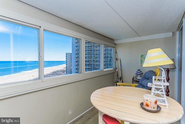 dining room with a water view, baseboards, and wood finished floors