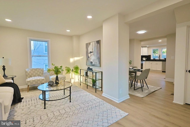 living area featuring light wood-style flooring, recessed lighting, and baseboards