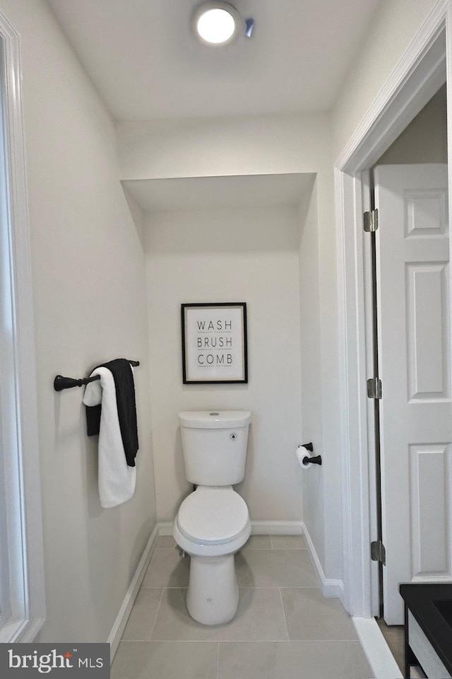 bathroom with tile patterned flooring, toilet, and baseboards