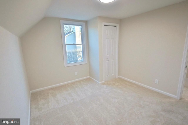 additional living space featuring carpet flooring, baseboards, and lofted ceiling