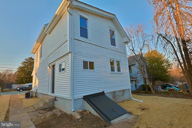 view of side of property with entry steps and central air condition unit