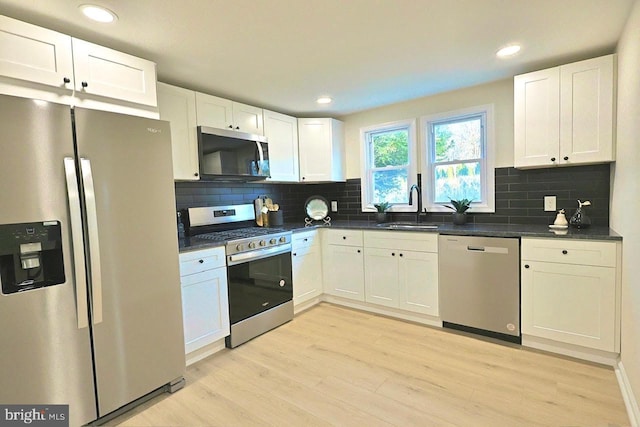 kitchen featuring dark countertops, appliances with stainless steel finishes, and a sink