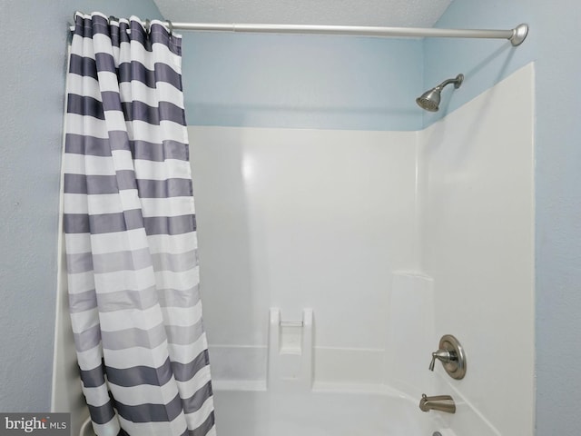 bathroom featuring a textured ceiling and shower / bath combo