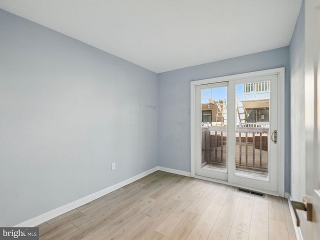 unfurnished room featuring baseboards, visible vents, and light wood-type flooring