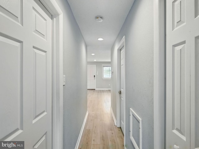 hallway featuring recessed lighting, baseboards, and light wood-type flooring