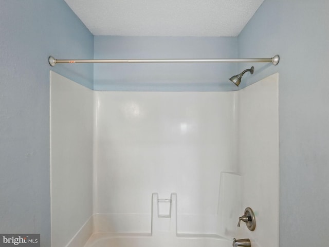 full bath with shower / tub combination and a textured ceiling