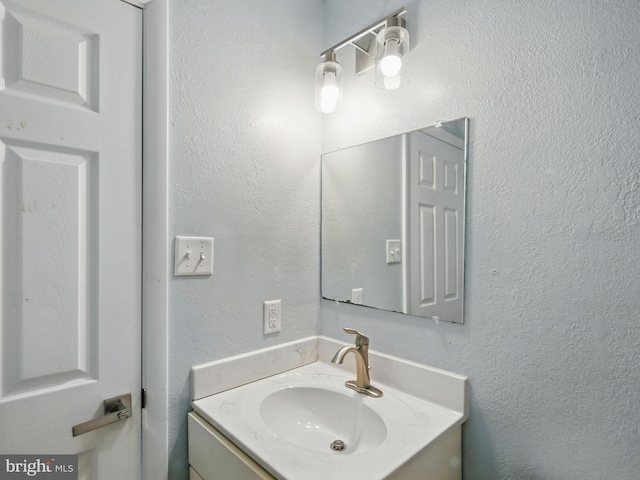 bathroom featuring vanity and a textured wall