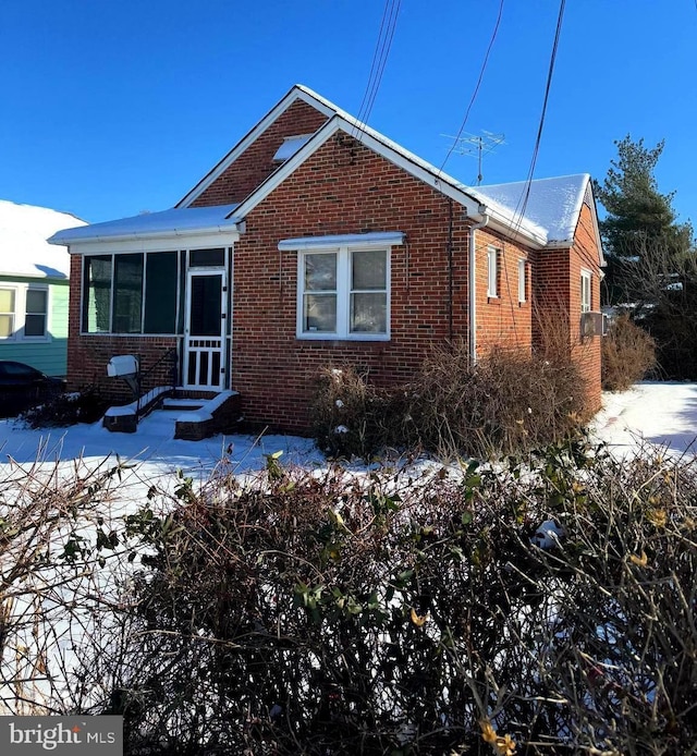 view of front of house featuring brick siding and a sunroom