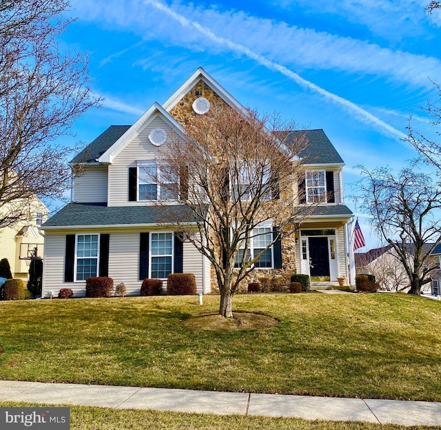 view of front of home with a front yard and roof with shingles