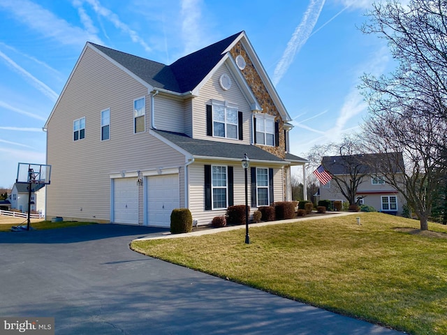 view of front facade with aphalt driveway, an attached garage, a front yard, and stone siding