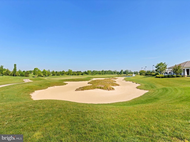 view of community featuring a yard and view of golf course