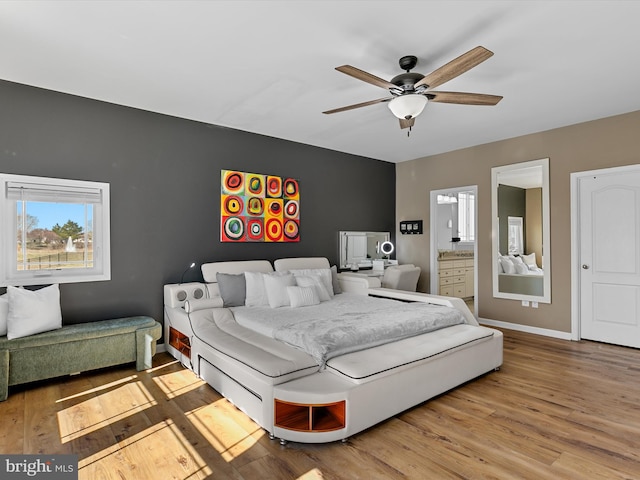 bedroom featuring connected bathroom, ceiling fan, baseboards, and wood finished floors