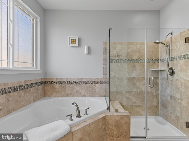 bathroom featuring a stall shower and a bath