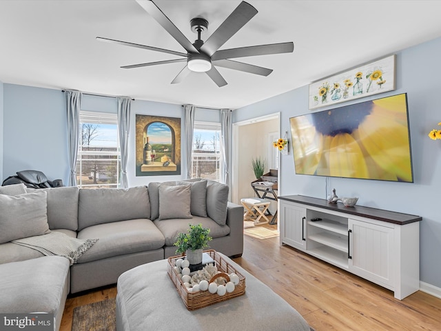 living room featuring ceiling fan, baseboards, and light wood-style floors