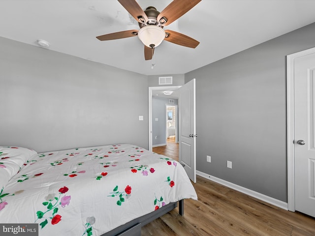 bedroom with visible vents, baseboards, and wood finished floors