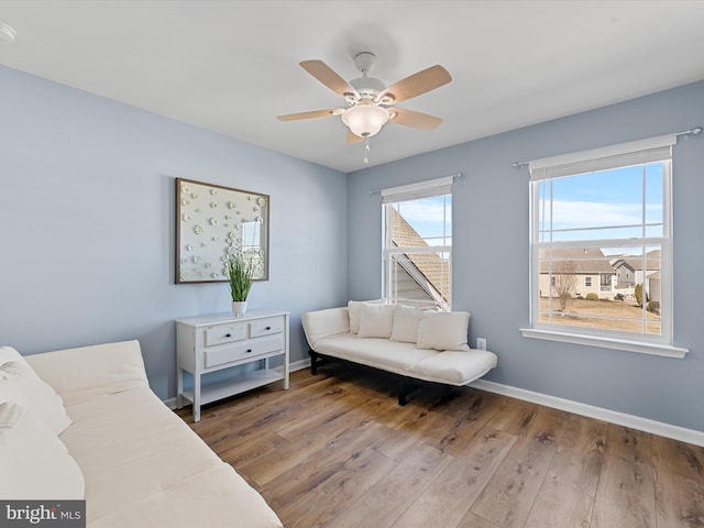 sitting room featuring wood finished floors, baseboards, and ceiling fan