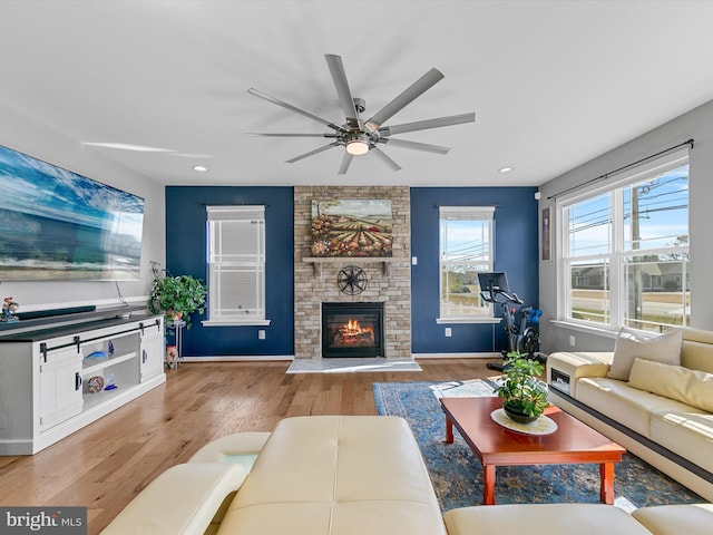 living area with wood finished floors, recessed lighting, a fireplace, baseboards, and ceiling fan