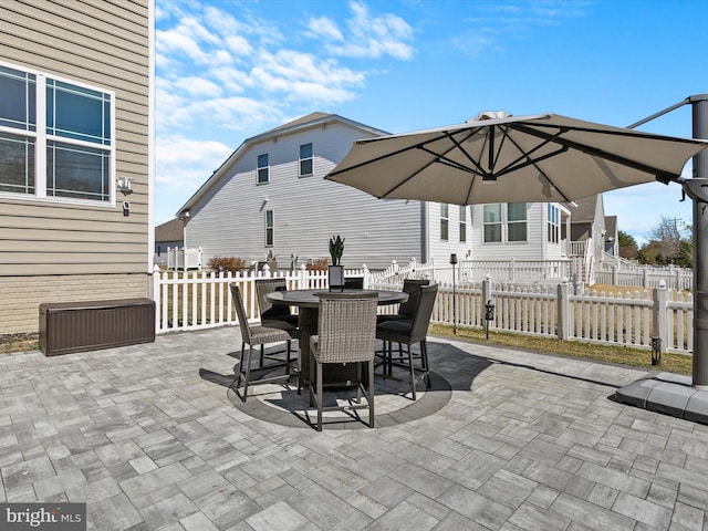 view of patio with outdoor dining space and fence