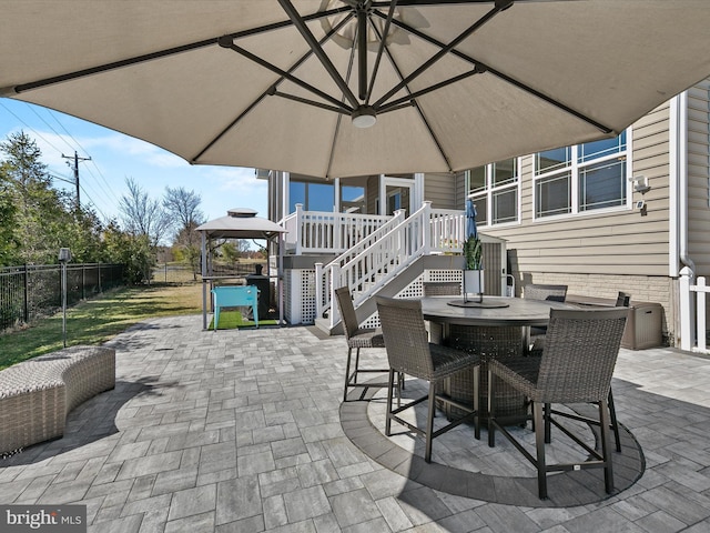 view of patio featuring a gazebo, outdoor dining space, stairway, and a fenced backyard