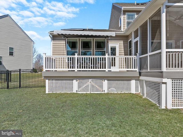 rear view of property featuring a sunroom, a yard, and fence