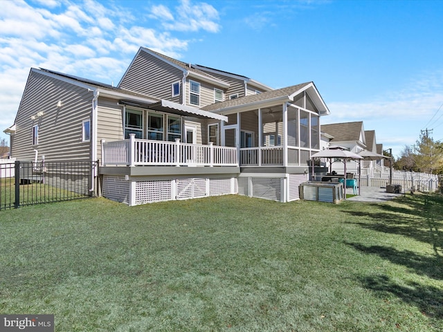 rear view of property with a yard, a patio, a fenced backyard, and a sunroom