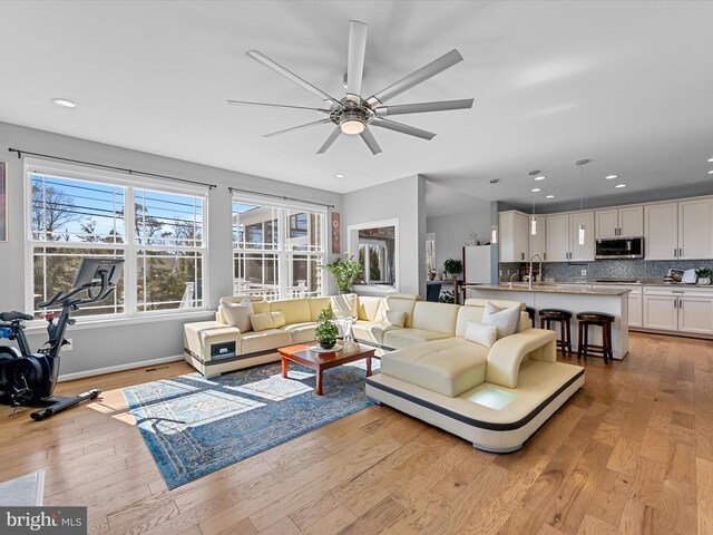 living room with recessed lighting, light wood-style flooring, and ceiling fan