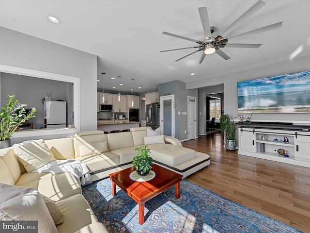 living room featuring recessed lighting, dark wood finished floors, and ceiling fan