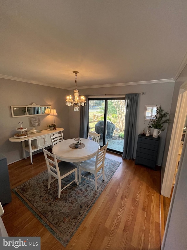 dining room featuring light wood-style flooring, crown molding, and an inviting chandelier