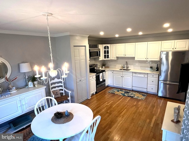 kitchen with dark wood finished floors, a sink, light countertops, white cabinets, and appliances with stainless steel finishes