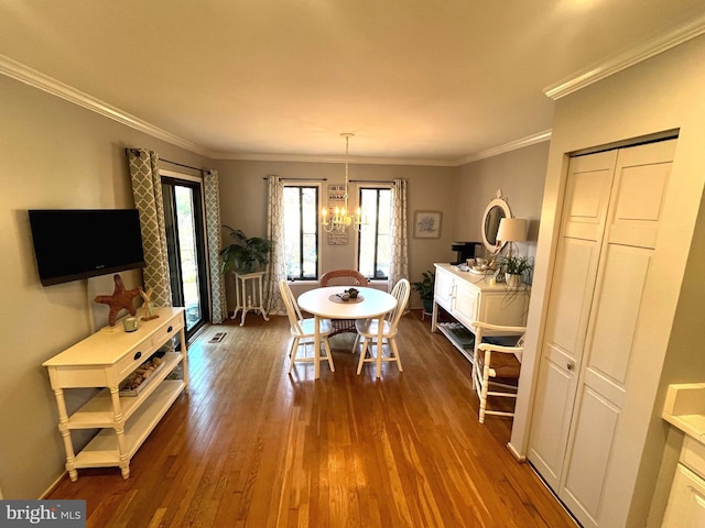 dining room featuring visible vents, an inviting chandelier, ornamental molding, and dark wood-style flooring