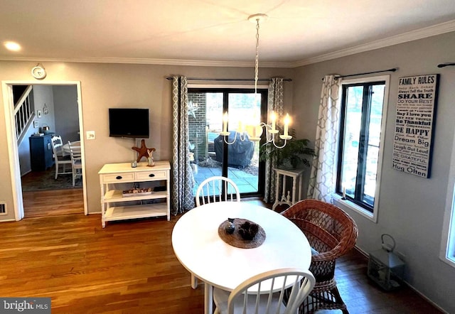 dining room with ornamental molding, wood finished floors, and a healthy amount of sunlight