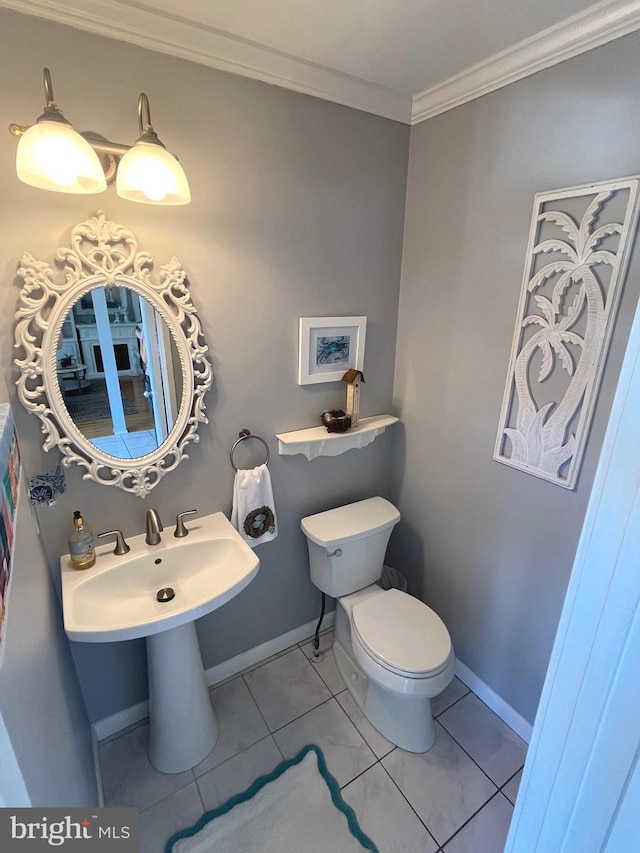 half bath featuring baseboards, toilet, ornamental molding, and tile patterned flooring